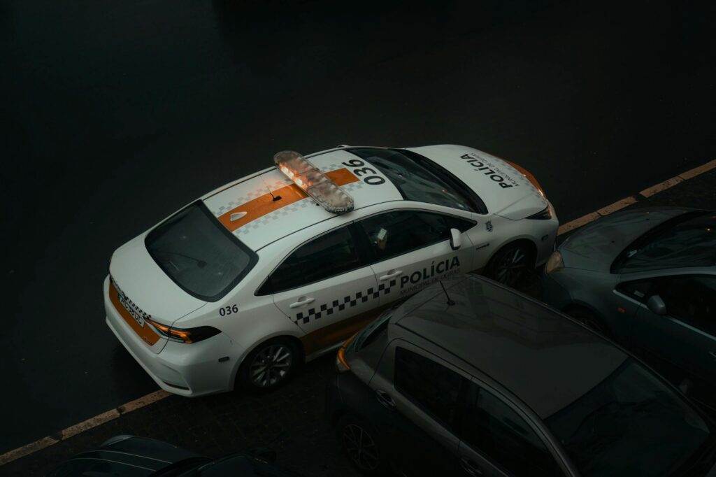 Aerial view of a police car parked on a street in Lisbon, Portugal, during the day.