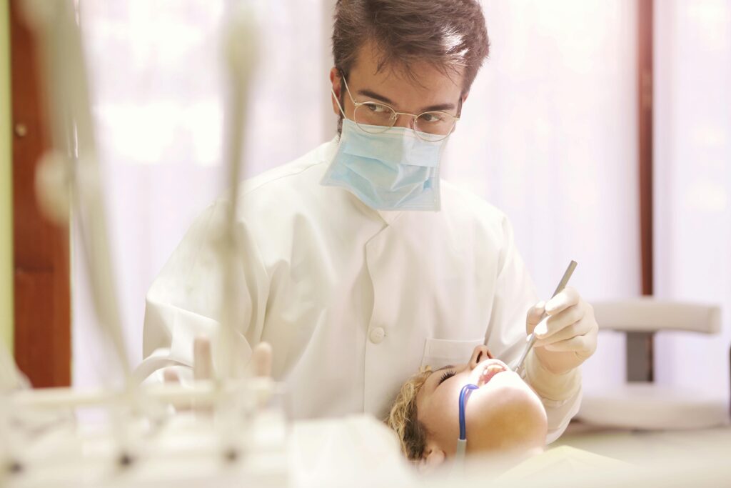 Professional dentist examining patient using dental tools in a clinic.