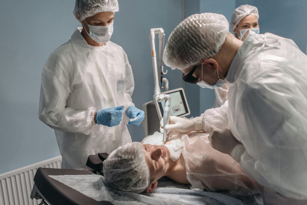 A team of doctors performing a facial laser procedure in a sterile operating room.