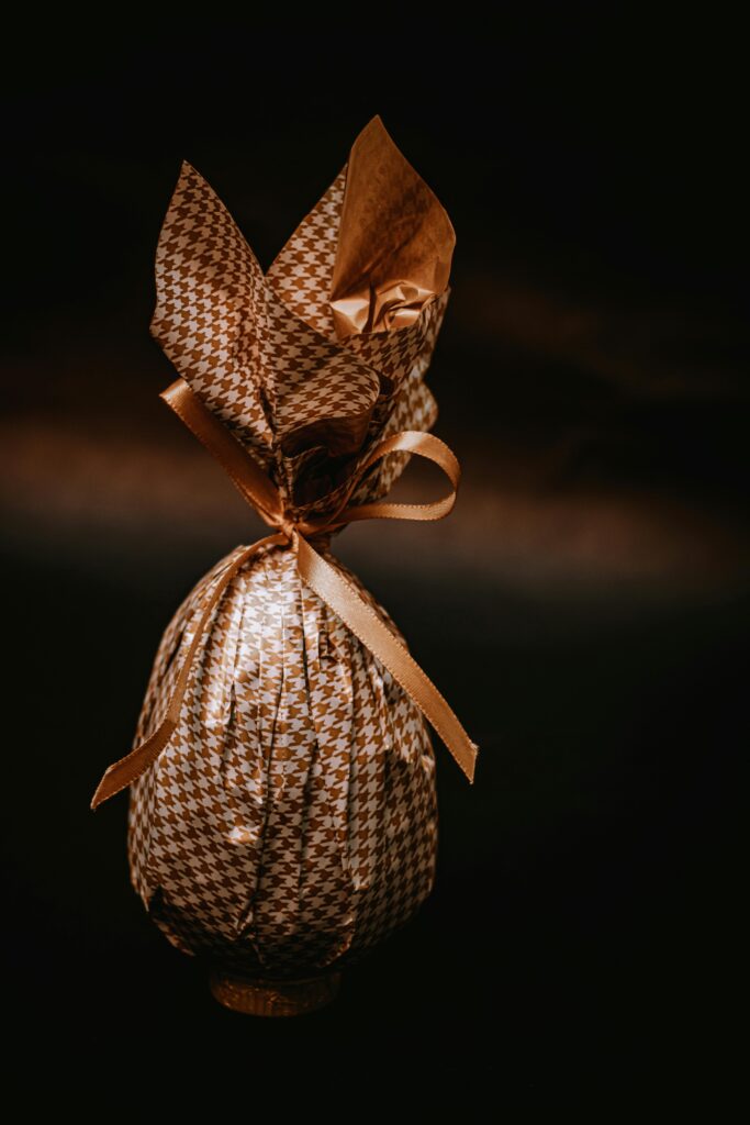 Stylishly wrapped chocolate egg with ribbon and bow, perfect for festive celebrations.