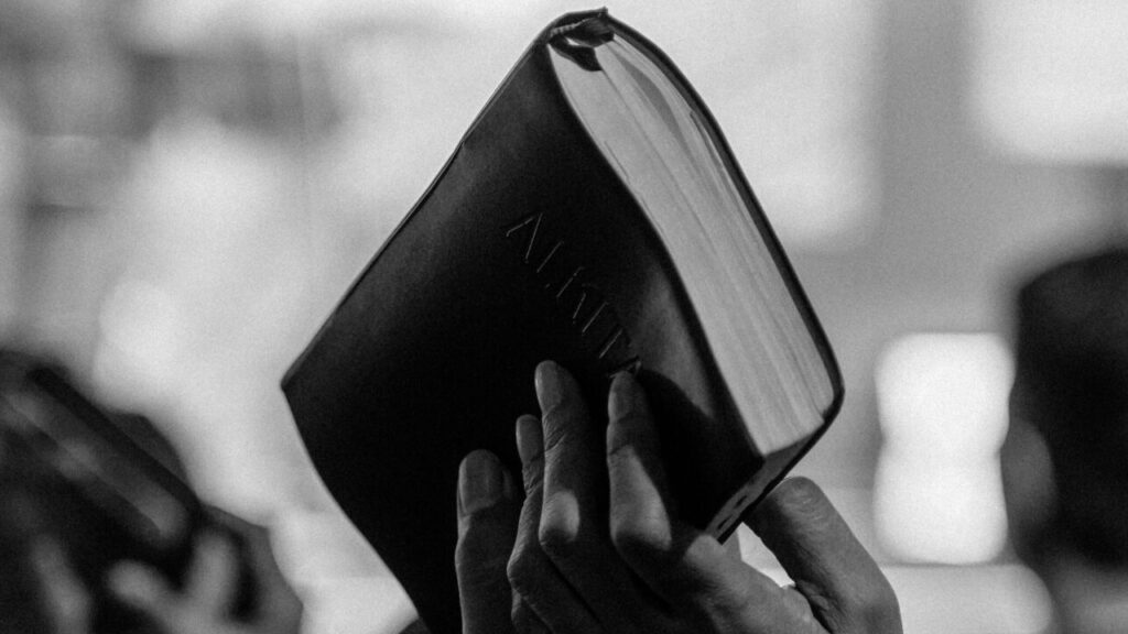 Monochrome image of a religious congregation in Jakarta, Indonesia, with raised Bibles.