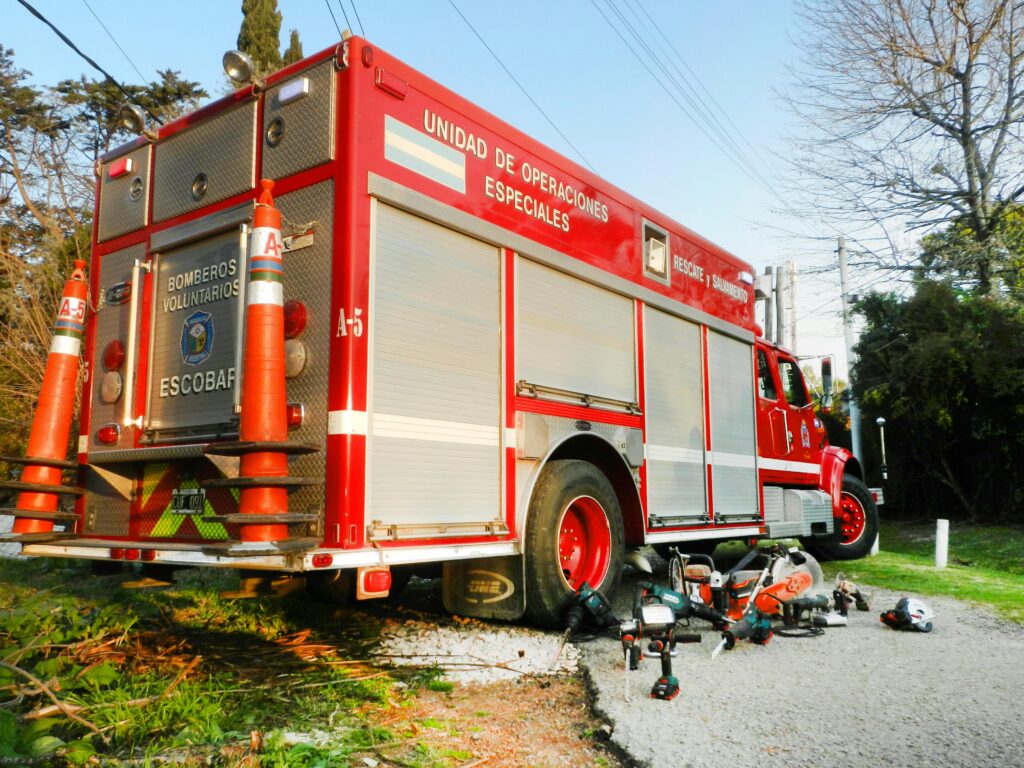 A red fire truck with rescue tools parked on a street, indicating emergency readiness.